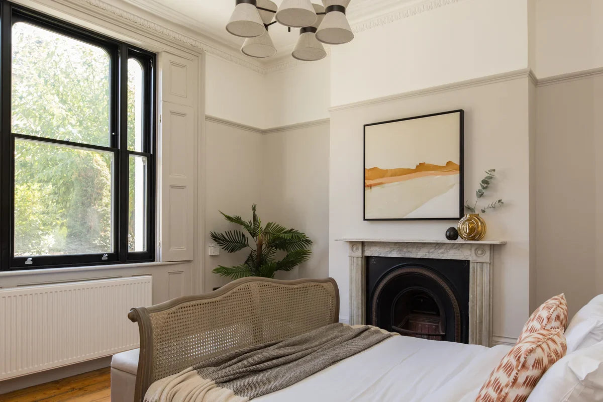 Forever Wandering, a warm and earthy abstract landscape canvas art pictured above a marble fireplace in a modern bedroom