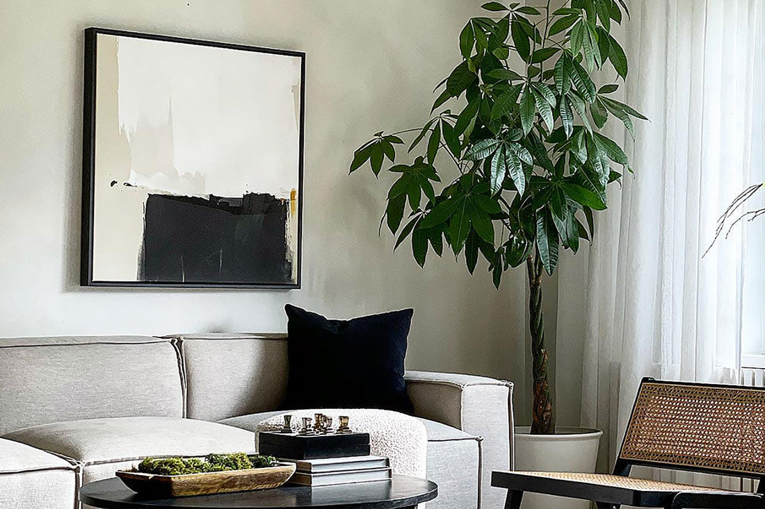 Minimal abstract framed canvas above neutral sofa in Japandi style living space